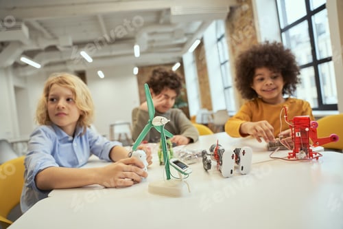 Preview: Close up shot of technical toys full of details on the table. Children sitting at the table and