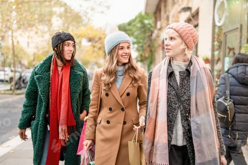 Preview: Diverse female friends walking together in autumn city street