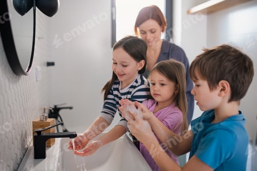 Preview: Mother supervising three little children in bathroom, morning routine concept