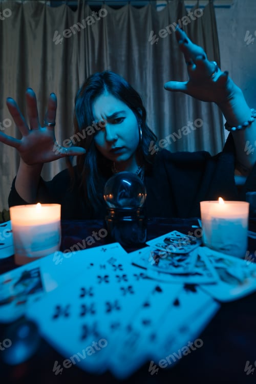 Preview: Woman fortune-teller guesses fate of night at table with candles