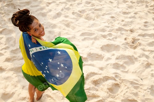 Preview: Overhead portrait of young woman wrapped in Brazilian flag, Ipanema beach, Rio De Janeiro, Brazil