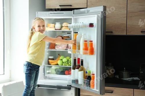 Preview: Girl taking bottle with juice out of refrigerator in kitchen