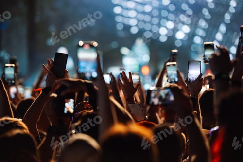 Preview: Crowd of fans holding smartphones recording video at a concert