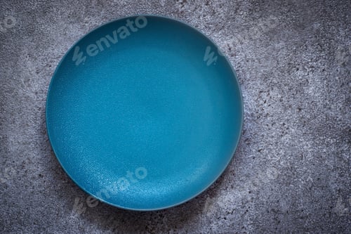 Preview: Empty turquoise ceramic plate On a concrete background. Top view