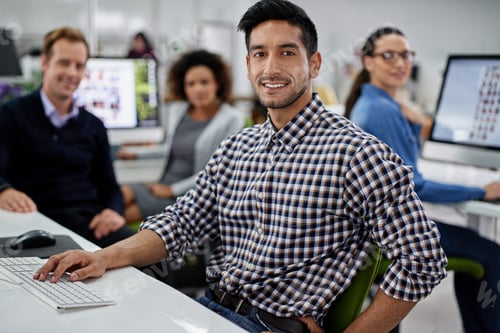 Preview: Smiling businessman looking at the camera with his coworkers in the background