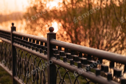 Preview: Metal black low fence in the park.