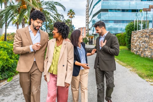 Preview: Relaxed business team talking walking along the city