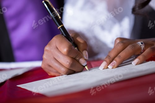Preview: Woman's Hands Signing Document with Black Ink Pen