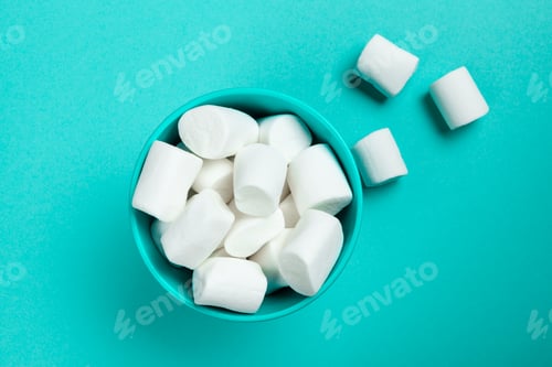 Preview: marshmallow laid out on blue paper background. pastel creative textured pattern