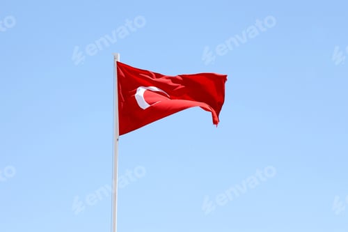 Preview: Turkish flag on flagpole waving in clean blue sky background