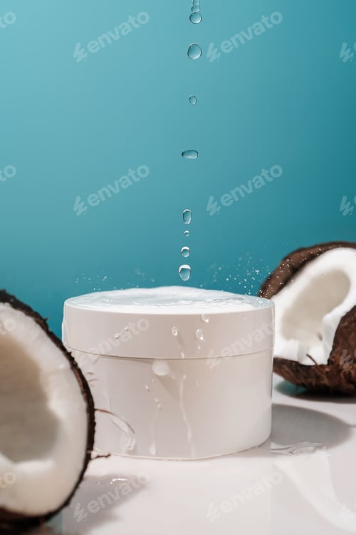 Preview: Two halves of coconut and a jar of cosmetics on a blue background with water drops