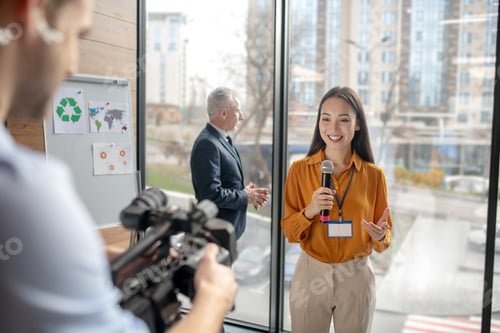 Preview: Dark-haired female reporter smiling to the camera