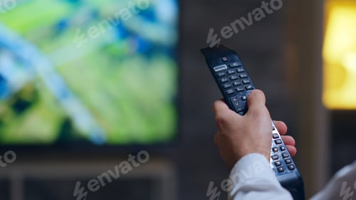 Preview: Back view of entrepreneur switching tv programs