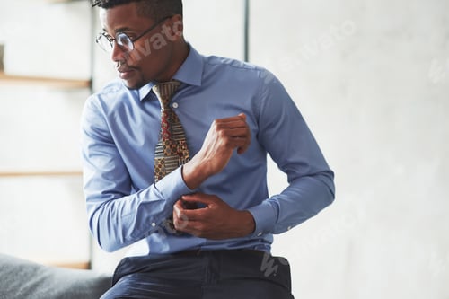 Preview: Professional Man Adjusting His Sleeve in Office Setting