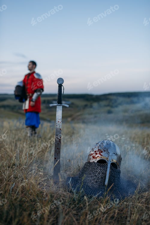 Preview: Sword stuck in the ground and metal knight helmet