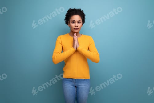Preview: calm young 25 year old hispanic lady with afro ponytail put her hands together for prayer