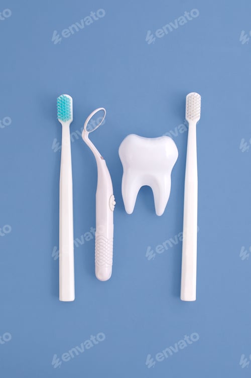 Preview: The concept of dentistry. A mirror for examining the oral cavity and a tooth and toothbrushes