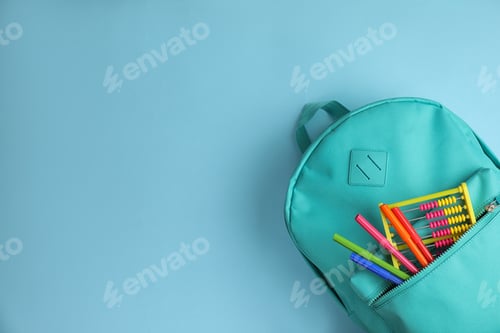 Preview: Stylish backpack with different school stationary on light blue background, top view. Space for text