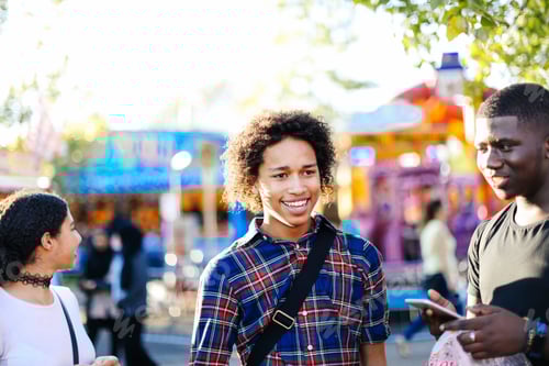 Preview: Group of friends at funfair, smiling