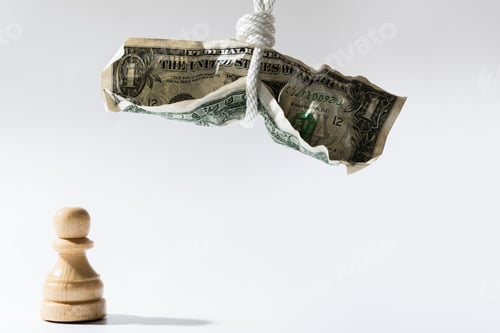 Preview: Crumpled one dollar bill hanging on a white rope with wooden chessman standing below.