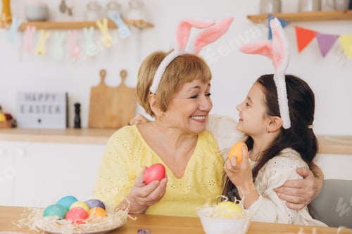 Preview: Happy easter! A grandmother and her granddaughter painting Easter eggs