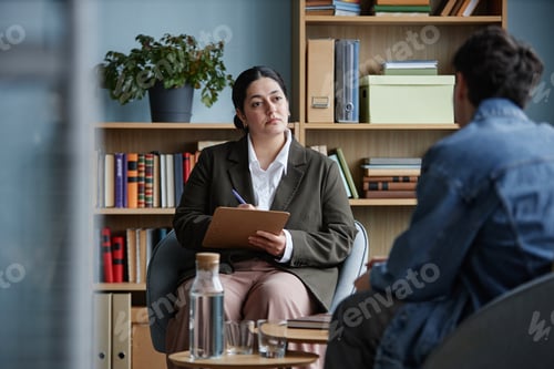 Preview: Teenage Boy Attending Counseling Session with Female Therapist in Office