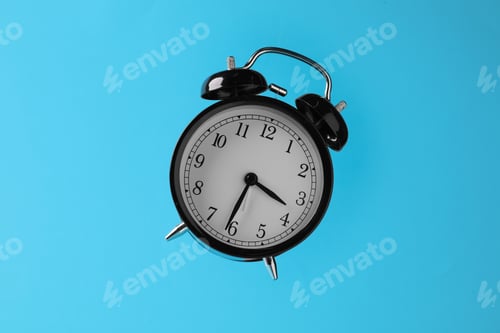 Preview: Black alarm clock in air on light blue background