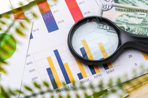 Preview: Business graphs and magnifying glass on table