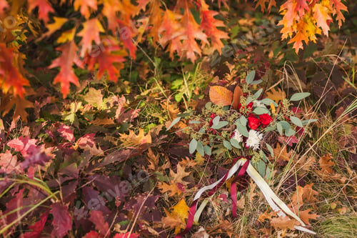 Preview: Beautiful bouquet of red and white flowers, lotus and eucalyptus with velvet ribbons on the grass