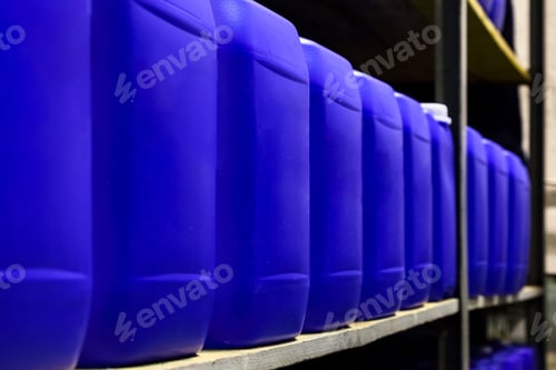 Preview: Close-up of rows liquid blue containers on rack in warehouse storage