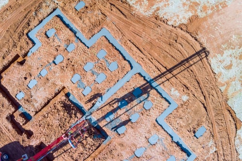 Preview: Builder pouring wet concrete to house foundation with using of a concrete pump