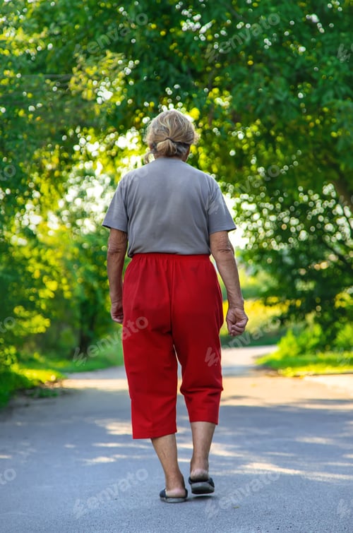 Preview: grandma is walking down the road. Selective focus.