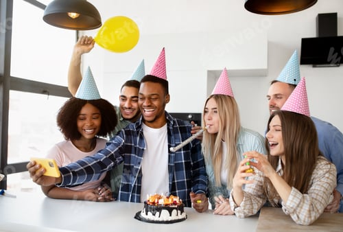 Preview: Cheerful group of diverse friends taking selfie while having birthday celebration with yummy cake at