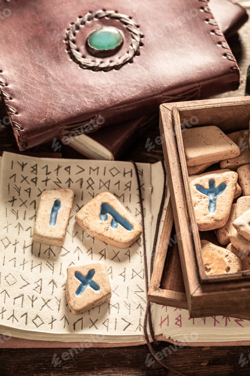 Preview: Book with futhark alphabet and runic stones as mystical background