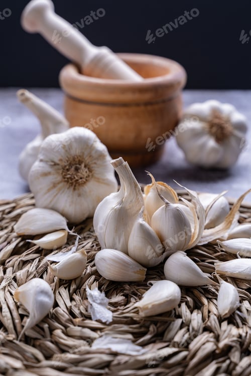 Preview: Top view of white garlic near a bowl