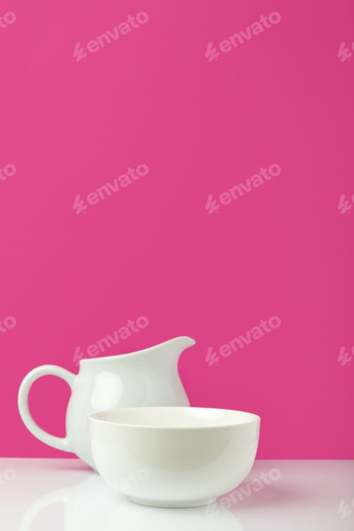 Preview: close-up view of empty white bowl and jug on pink