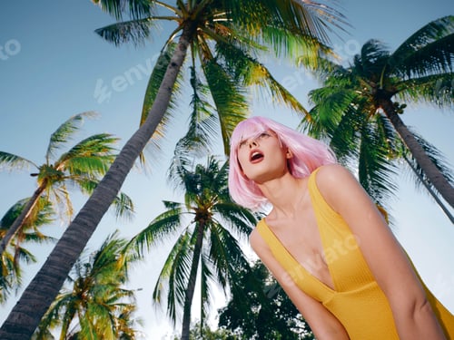 Preview: Pinkhaired woman in yellow dress stands with hands on hips, appearing surprised, with palm trees in