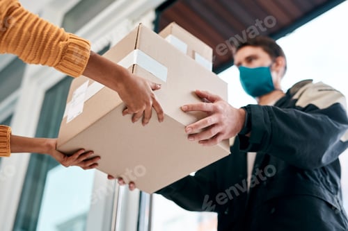 Preview: Shot of a masked young man delivery a package to a woman at home
