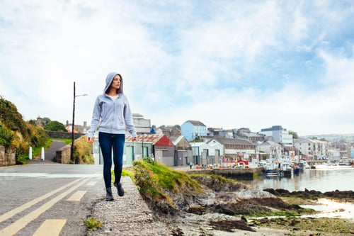 Preview: Full length of woman walking on road by harbor