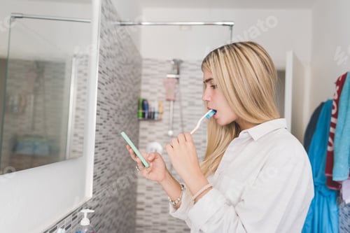 Preview: Woman Brushing Teeth While Looking at Phone