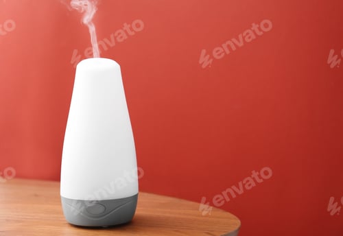 Preview: Essential oils diffuser on wooden table near red wall. Space for text