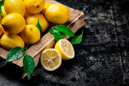 Preview: Lemons with leaves on a wooden tray.