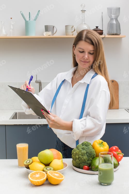 Preview: A young nutritionist woman makes a nutrition plan in her form while standing