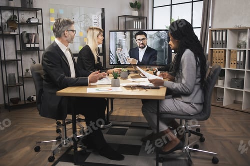 Preview: Confident bearded Caucasian man tells business program concept to his multinational colleagues