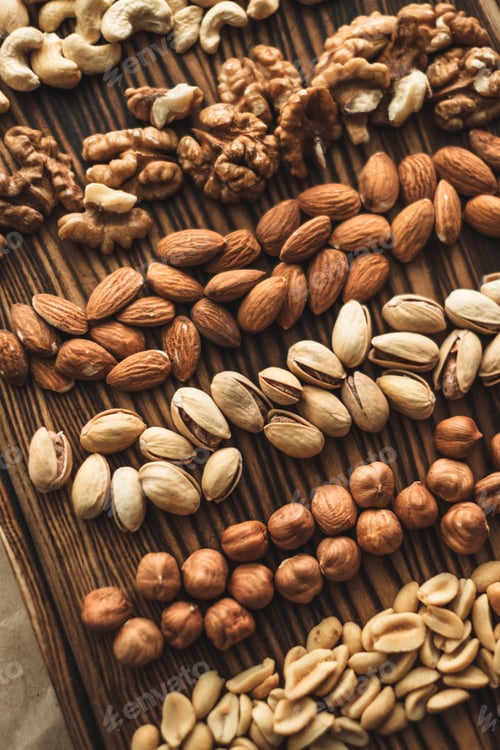 Preview: Different types of nuts, nut mix of almonds, hazelnuts, cashews, peanuts on a wooden board. Close up