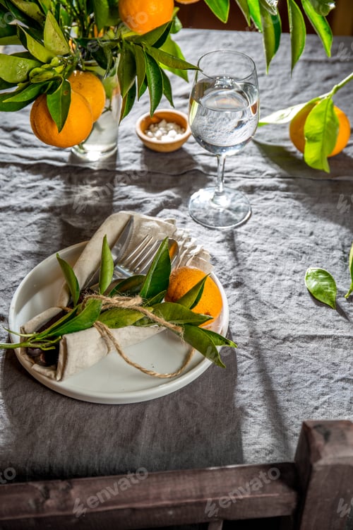 Preview: Table setting with white plate, cutlery, linen napkin and orange tree branch decoration