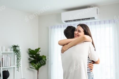 Preview: Caucasian young man and woman hugging each other in living room at home.