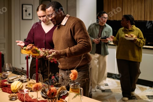 Preview: Diverse Young Adults Sharing Thanksgiving Dinner and Serving Festive Food