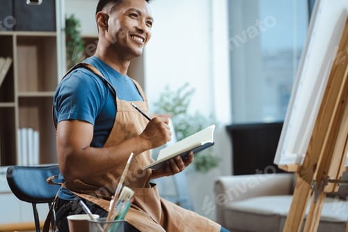 Preview: Male artist painting on canvas in the home studio, fine arts and creativity concept.