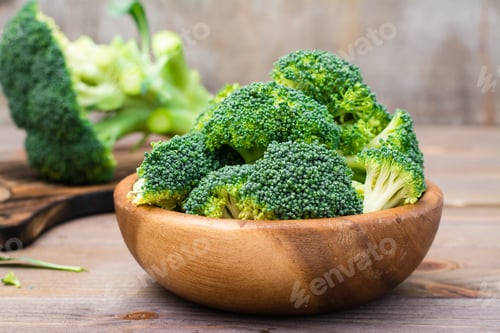 Preview: Ready to eat fresh raw broccoli is divided into inflorescences in a wooden plate